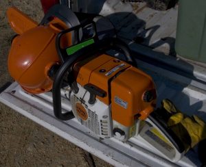 Picture of chainsaw and helmet on truck tailgate.