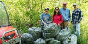 Image of volunteers posing with bags of garlic mustard